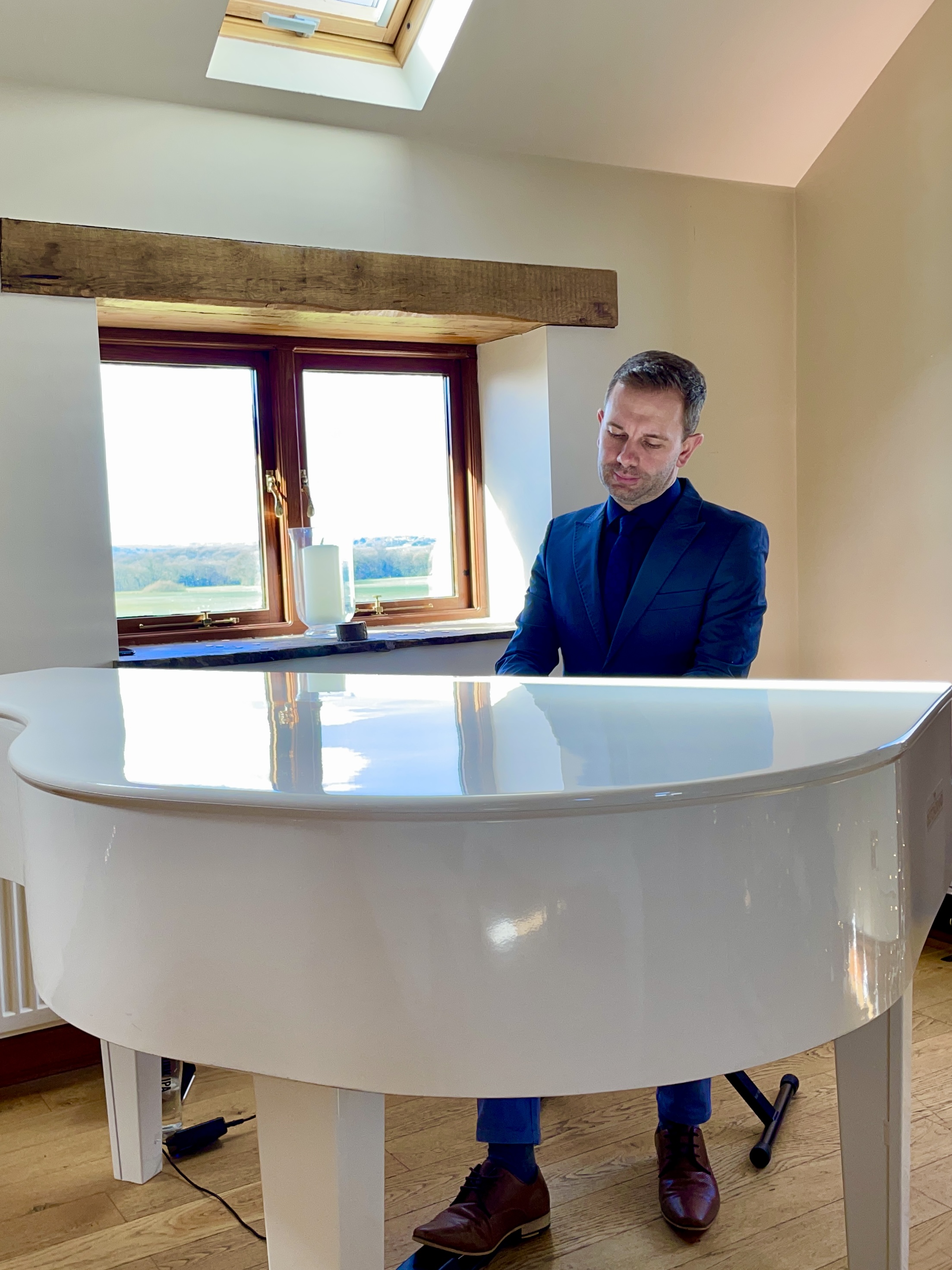 Craig Smith plays his white baby grand piano for a Beeston Manor wedding ceremony