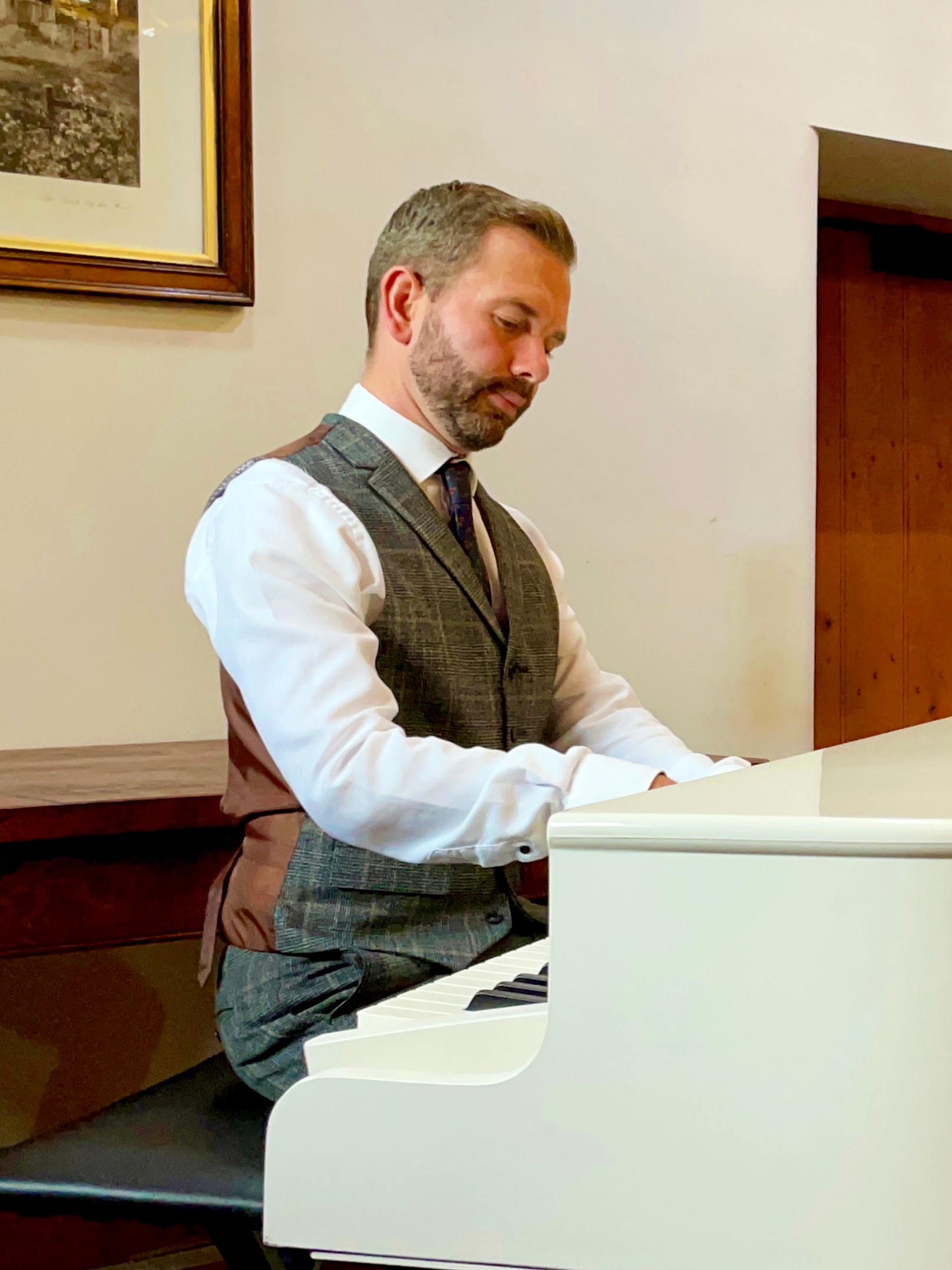 Craig Smith plays his white baby grand piano at a Browsholme Hall Tithe Barn drinks reception