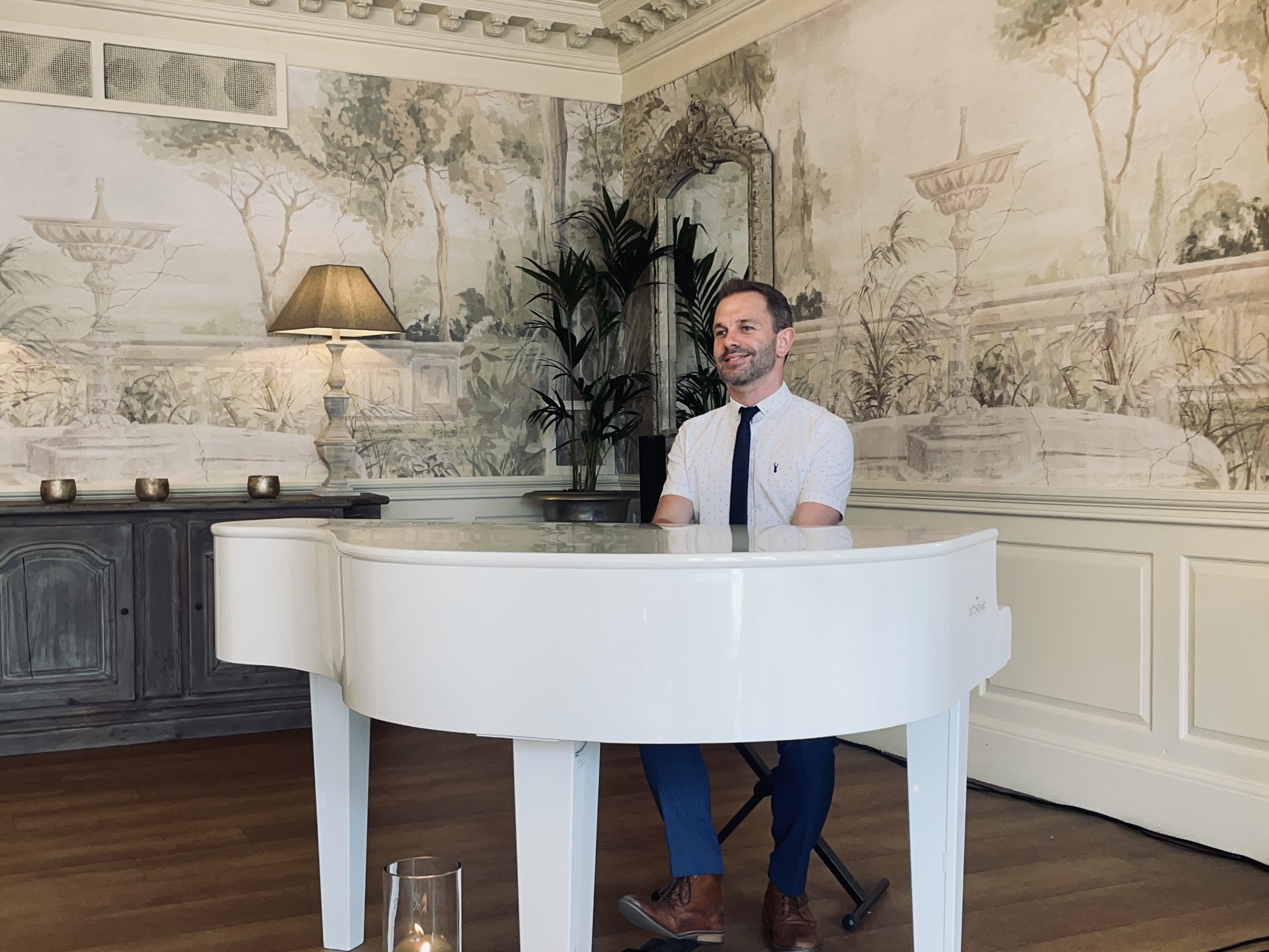 Eaves Hall wedding pianist Craig Smith plays his white piano in the Ballroom