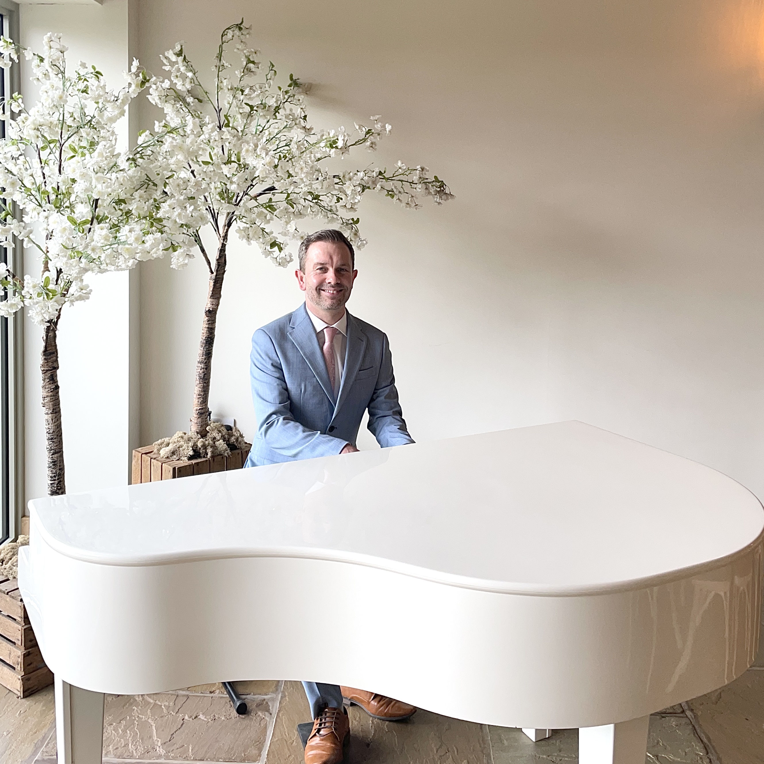 Wedding pianist Craig Smith plays his white baby grand piano for a Hobbit Hill wedding ceremony