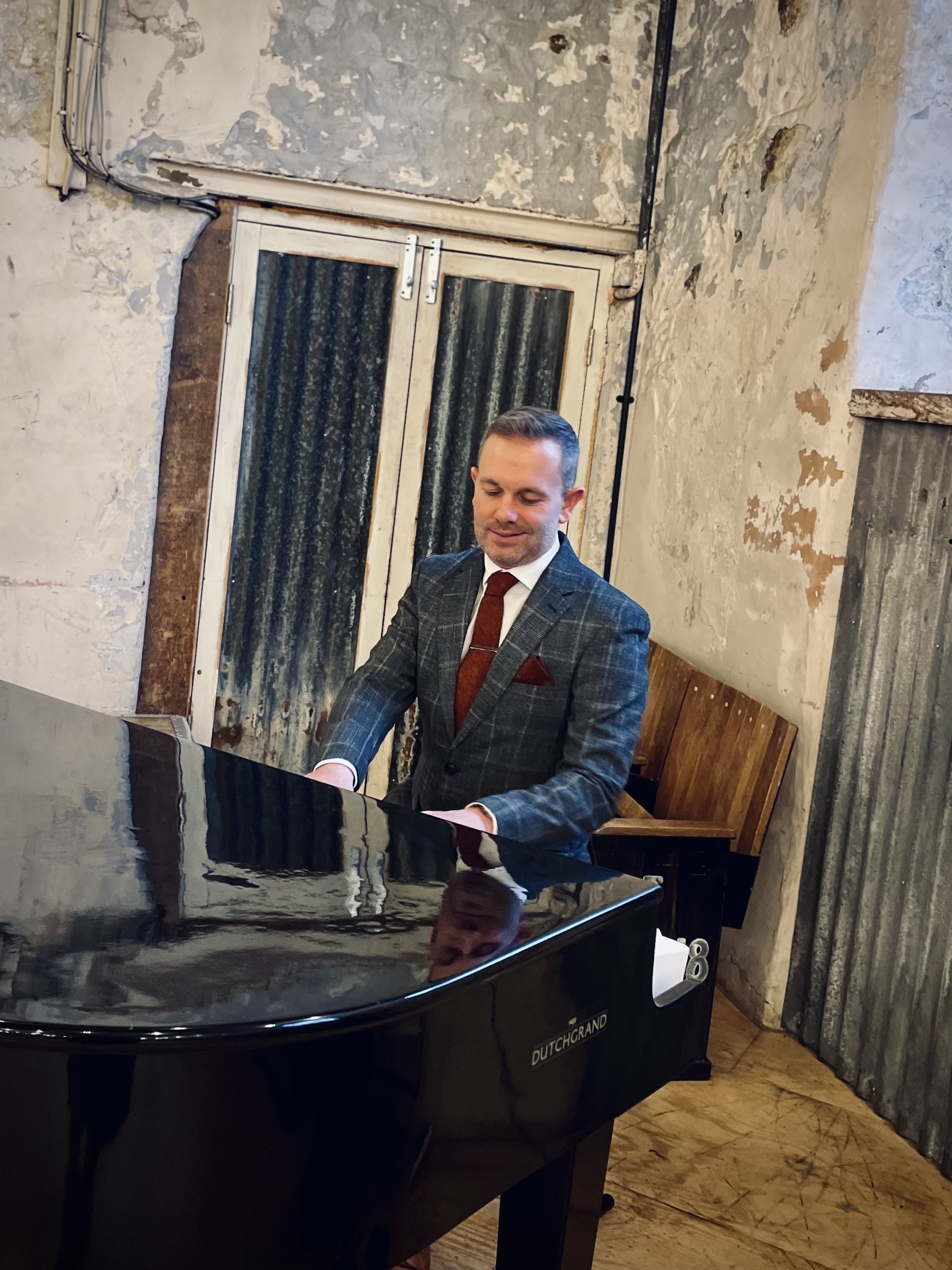 Craig Smith plays piano during a wedding ceremony at Holmes Mill