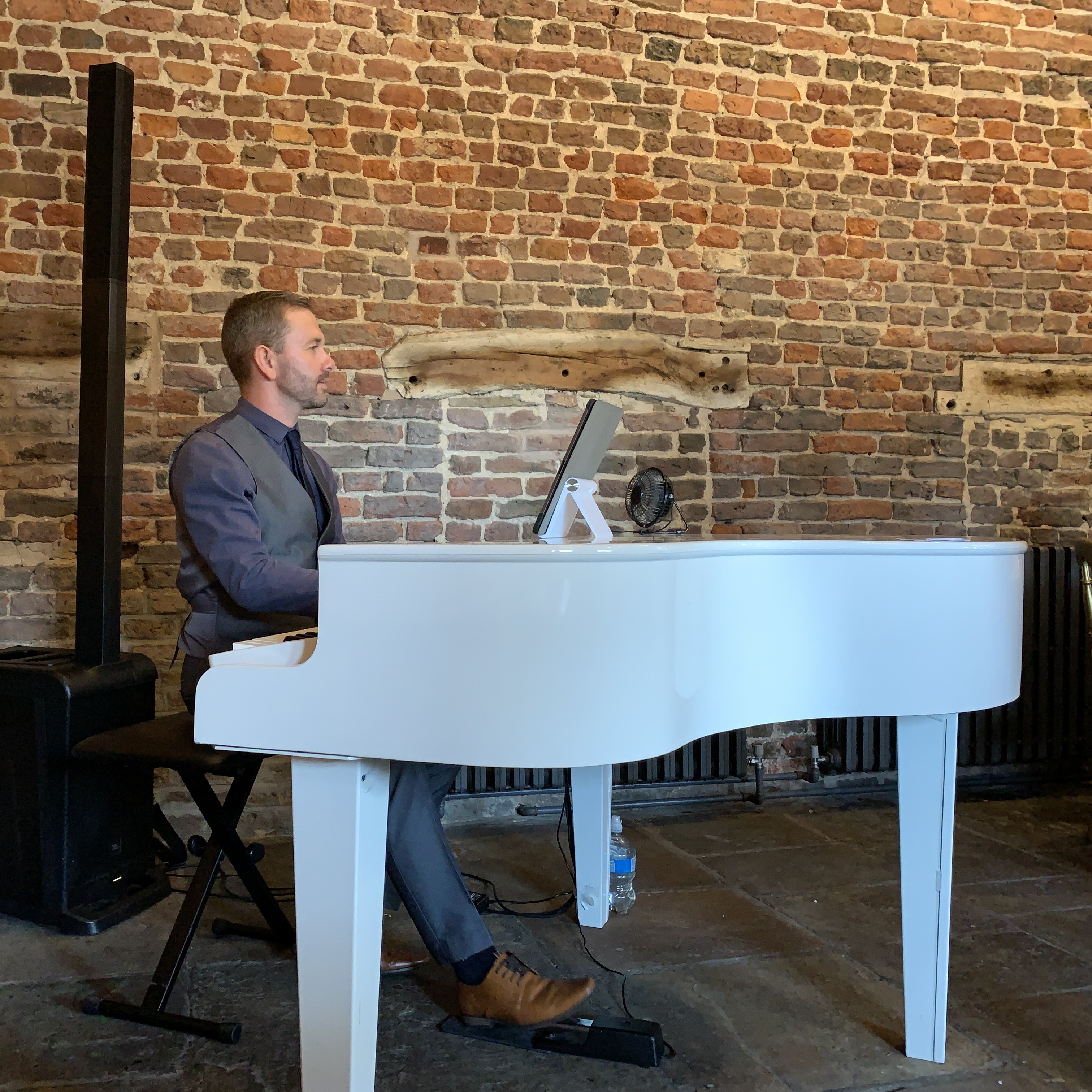 Meols Hall wedding pianist Craig Smith plays a white grand piano during a wedding breakfast