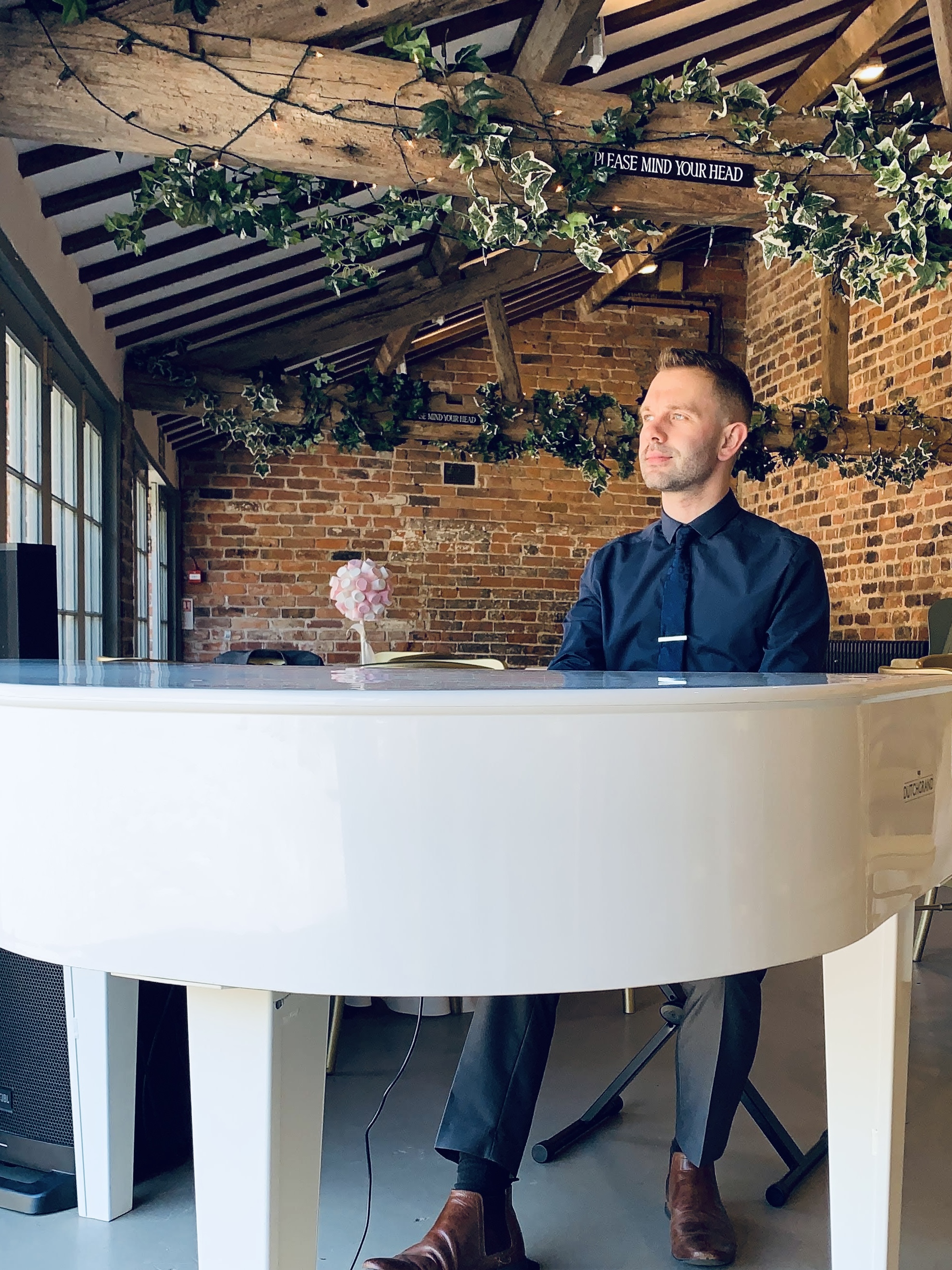 Craig Smith plays his white baby grand piano during a Meols Hall wedding drinks reception