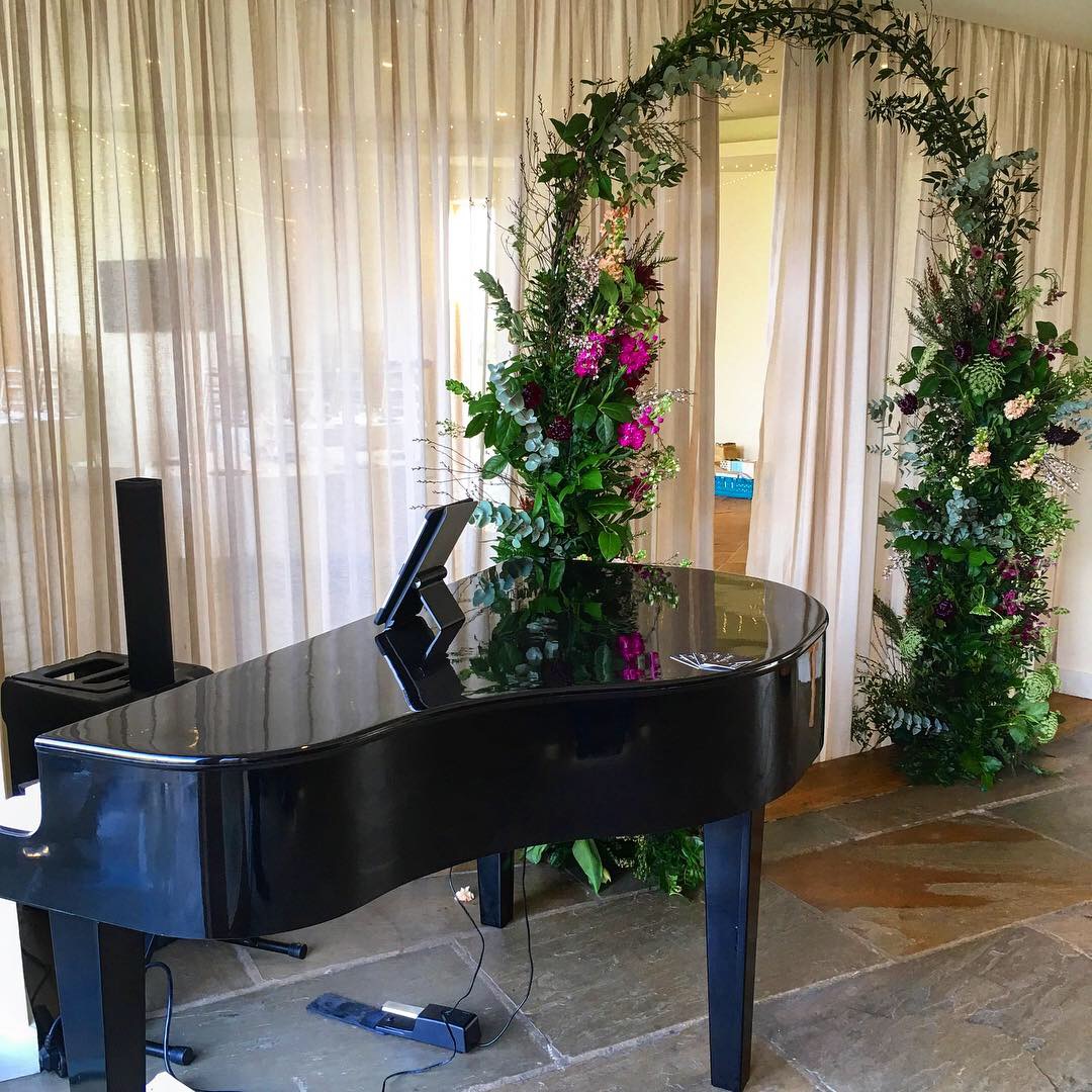 Out Barn wedding pianist Craig Smith's black baby grand piano set up ready to welcome guests to the venue