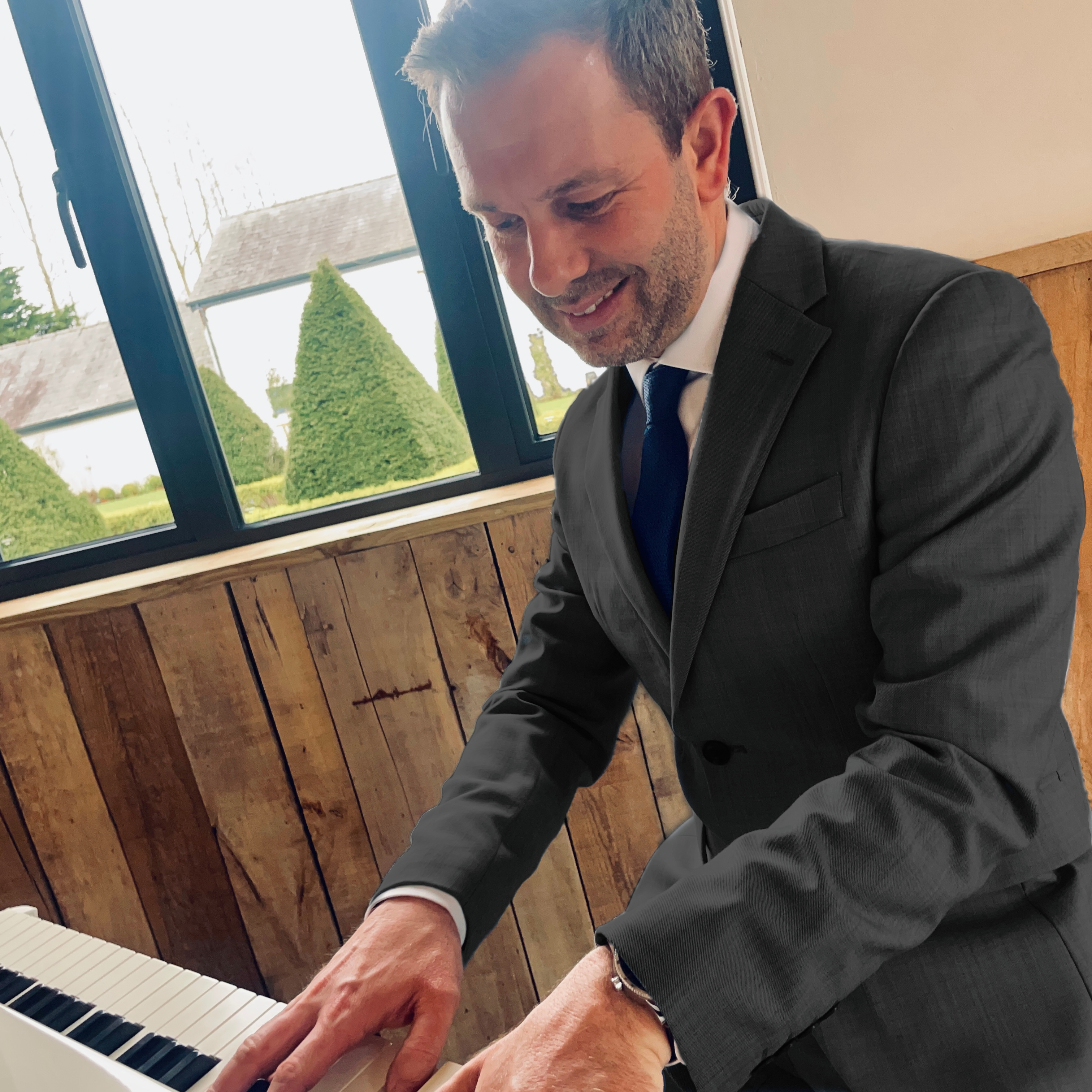 Craig Smith plays wedding piano during a River Barn wedding ceremony
