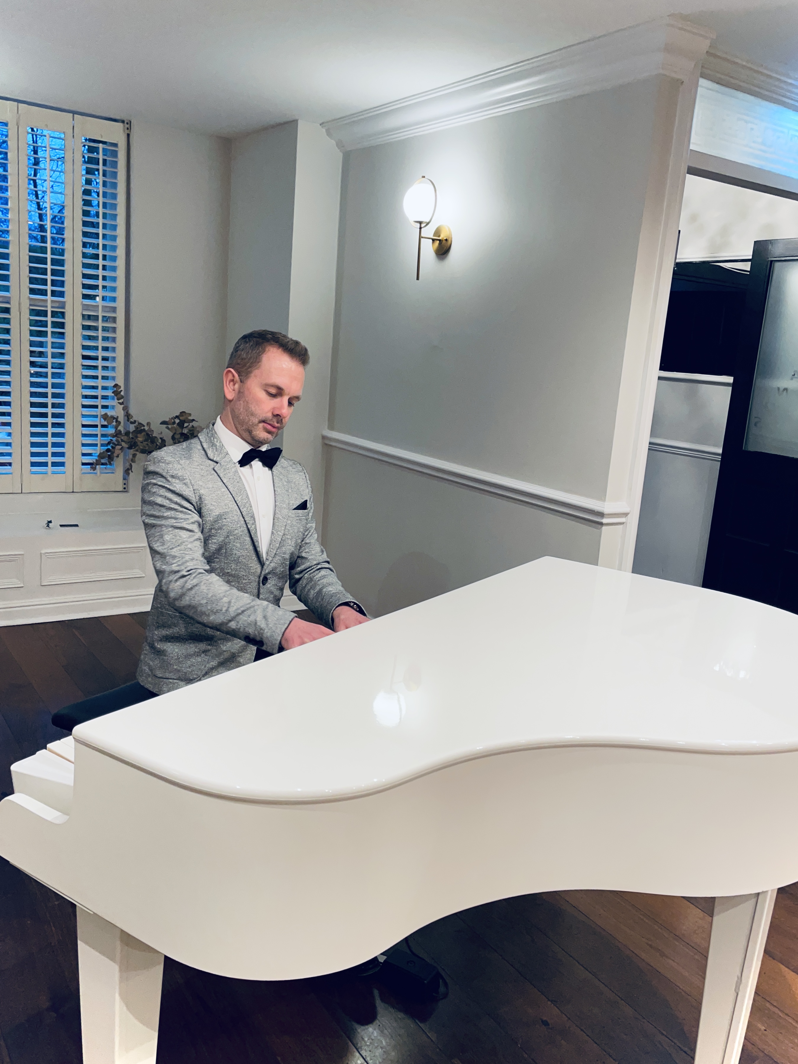Sparth House wedding pianist plays his white piano during a wedding ceremony.