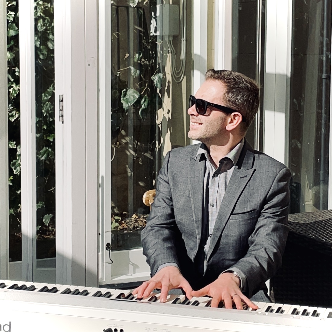 Wedding pianist Craig Smith performs during a wedding drinks reception on a sunny West Tower lower patio